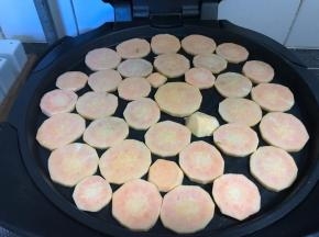 电饼铛盘子里刷一层薄油，把红薯片平铺在电饼铛里；平底锅也可以，但电饼铛受热更均匀，而且电饼铛的盘子比较大，一次可以做很多；