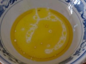 牛奶和玉米油倒在一个大碗里，用手动打蛋器搅拌均匀；