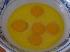 将五个鸡蛋的蛋黄也敲在大碗里；（蛋清放在一个无油无水的打蛋盆里待用）