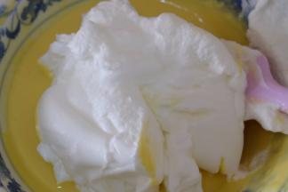 取一半蛋白放进蛋黄糊里，用刮刀从下往上翻拌均匀；