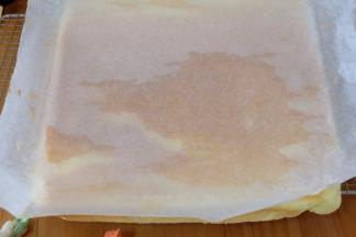 蛋糕胚子烤好之后，取出来倒扣在晾网上，迅速撕下油纸，撕下的油纸还继续盖蛋糕上；