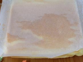 蛋糕胚子烤好之后，取出来倒扣在晾网上，迅速撕下油纸，撕下的油纸还继续盖蛋糕上；