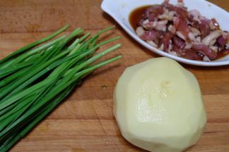 把土豆去皮洗净，韭菜去黄叶洗净，猪肉切成肉丝，用生抽酱油腌制几分钟备用；