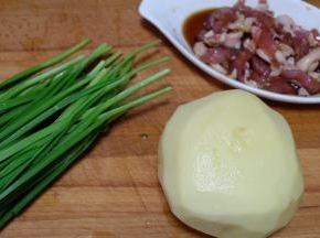 把土豆去皮洗净，韭菜去黄叶洗净，猪肉切成肉丝，用生抽酱油腌制几分钟备用；