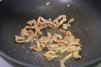 炒锅上火烧热，放食用油，再把肉丝放进去翻炒变色；