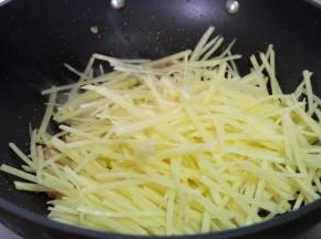 把土豆丝沥水，放进锅里翻炒；