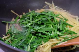 土豆基本成熟以后再把切好的韭菜段放进去，加盐调味，继续翻炒均匀；