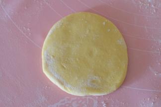 取其中一个面团，用擀面杖擀成一个圆饼，不要擀太薄了；厚约0.5CM左右；