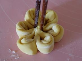 用筷子插在对应的两个花瓣里，用力夹一下，使花瓣黏连，形成一朵花；