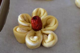 取一颗小红枣，放在花心和，用手往下按压固定，一朵小花就做好了；