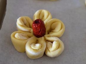 取一颗小红枣，放在花心和，用手往下按压固定，一朵小花就做好了；