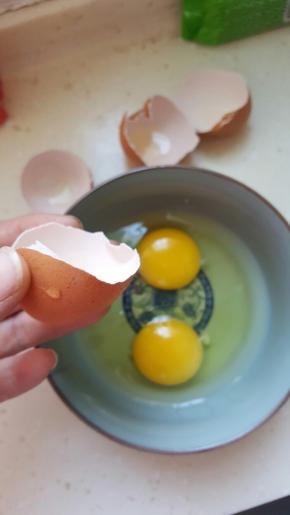 准备两个鸡蛋放到碗里，留一半鸡蛋壳清水冲洗干净备用