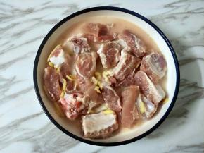 把水淀粉倒入腌好的排骨中