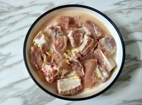 把水淀粉倒入腌好的排骨中