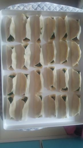 拿起面片放在手上，抹上馅料，中间捏紧两头不要捏，摆到烤盘上