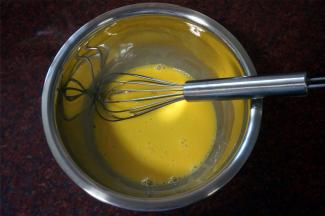 冷却蛋糕的过程，制作巧克力奶油馅。将2个蛋黄打散，加入15克全脂牛奶，拌均匀。