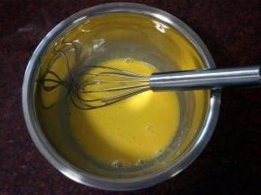 冷却蛋糕的过程，制作巧克力奶油馅。将2个蛋黄打散，加入15克全脂牛奶，拌均匀。