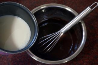 将刚煮沸腾的牛奶倒入可可粉蛋黄面糊中，边倒边搅拌，然后将混合物过筛，重新倒入奶锅中。