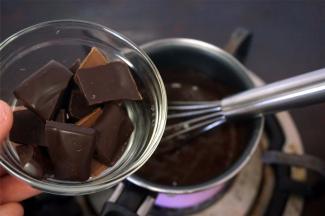 将黑巧克力碎加热入到热卡仕达酱中，拌至融化，然后坐入冰水搅拌冷却降温。