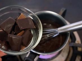 将黑巧克力碎加热入到热卡仕达酱中，拌至融化，然后坐入冰水搅拌冷却降温。