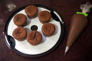 做好的巧克力奶油馅料装入带裱花嘴的裱花袋，将裱花嘴插入杯子蛋糕中，挤出馅料，蛋糕会重新变得饱满。