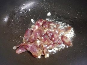 蒜炒出香味后加入切好和香肠翻炒