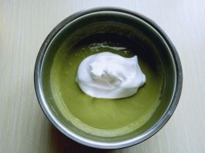 再取三分之一的蛋白霜加入蛋黄糊中，继续上面的手法，翻拌直至看不到蛋白霜。