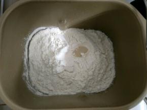 主料里除黄油外，其余材料全部放入面包机，按先液体后固体的顺序，盐跟糖对角线分开放