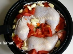 西红柿切块、大蒜用刀压扁，放在鸡腿和蔬菜的缝隙中