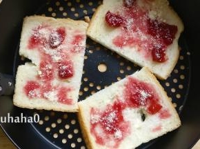 土司对半切开放在炸蓝中，土司比较大，小土司可以不用切，抹上一层樱桃酱或者番茄沙司，撒一点芝士粉