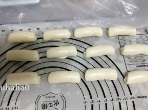 取一个面团压扁、擀开成牛舌状，自上而下卷起，和做蛋黄酥是一样，这是第一次擀卷