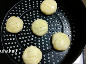 取面团擀开，包入馅料，捏紧收口，放入空气炸锅的炸蓝中，炸蓝中不用铺油纸，面团表面先刷蛋液，后用小刀划上三道口子，避免在烘烤过程中爆馅
