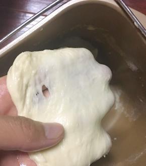 面团揉至略有筋度是加入黄油，继续揉至能拉出结实的薄膜