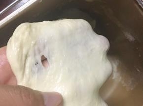 面团揉至略有筋度是加入黄油，继续揉至能拉出结实的薄膜