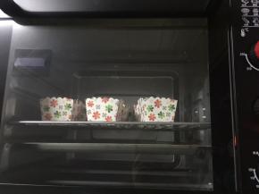 将面糊倒入小蛋糕纸杯中，烤箱160度预热，烤盘加水，150度烤45分钟左右