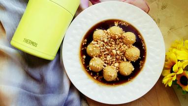 成品图。用叉子插起一个丸子，咬一口，红糖的甜，花生碎的香脆，糯米的软糯，尽在口中。一边吃一边蘸着糖浆，一口一个满足。