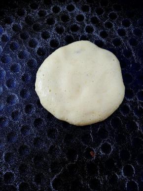 电饼铛刷不刷油都可以，平底锅也可以，不沾的就行。倒入一勺鸡蛋面糊，用勺子轻压面糊画圈圈，把面糊摊开。