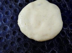 电饼铛刷不刷油都可以，平底锅也可以，不沾的就行。倒入一勺鸡蛋面糊，用勺子轻压面糊画圈圈，把面糊摊开。