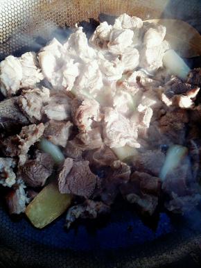 香味出来后，倒入一勺白糖，翻炒几下。然后调中火，把牛肉倒入翻炒。