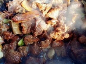 翻炒两三分钟后，倒入两勺黄酒去腥，两勺酱油调味，一勺老抽上色。翻炒均匀。