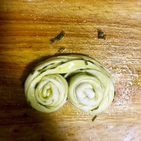 捏住两端向中间方向对卷