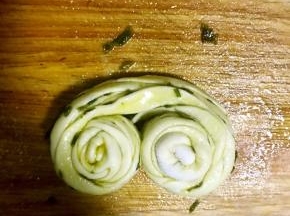 捏住两端向中间方向对卷