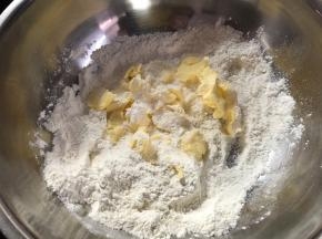 把100克面粉、盐、20克糖粉倒入盆里混合均匀。将黄油切成小块放入面粉混合物里。