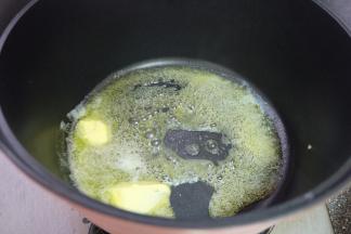 先来制作苹果派的馅，准备好主料表里的食材，苹果去皮去核切成小块，不粘锅里放上黄油，加热，让黄油彻底融化；