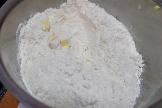 现在来做派皮，准备辅料表里的食材，先把黄油切成小块，不用软化，直接切小块就可以了，放进一个小盆里，再倒进低筋面粉和白糖；