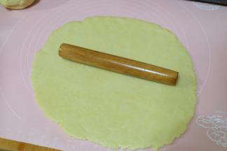 将大一点的面团用擀面杖擀开，擀成厚度约0.3CM的皮；