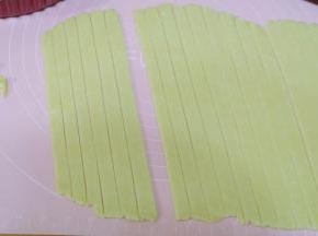 把另一块面团擀开，厚度约0.3CM，然后切成[宽度一致的长条；