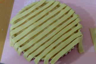 派皮内放满苹果馅，再把切好的长条铺在上面；先铺一层（如图所示）