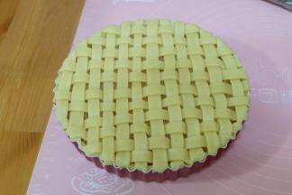 把边角多余的派皮用手按压去掉就可以了；用辅料中的蛋黄和适量清水调合成蛋黄水，用毛刷刷在派皮表面；