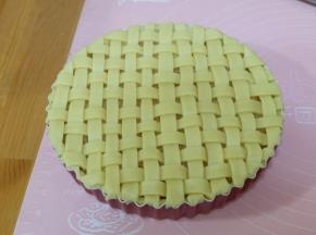 把边角多余的派皮用手按压去掉就可以了；用辅料中的蛋黄和适量清水调合成蛋黄水，用毛刷刷在派皮表面；